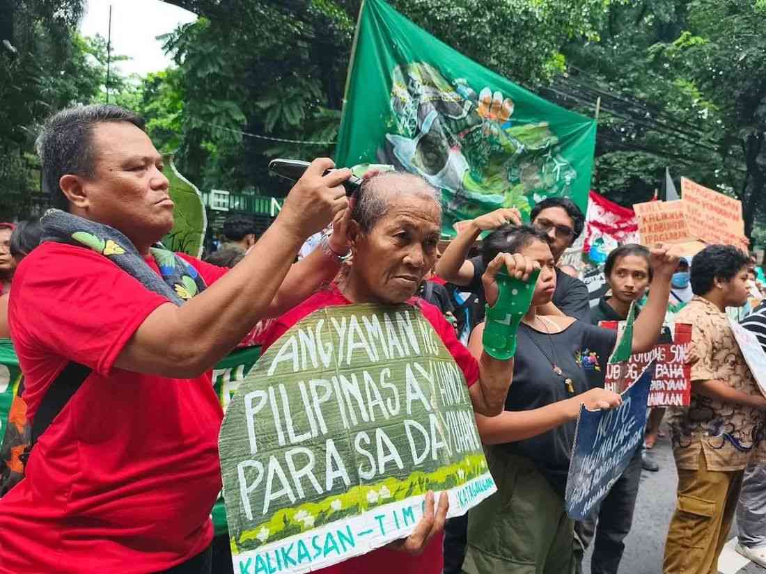 Protesters shave their heads in demonstration vs. widespread deforestation in front of DENR office